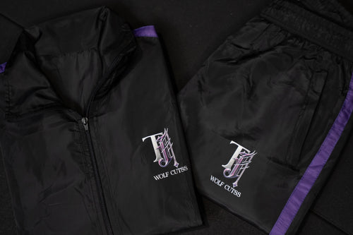 TJ Wolf Cutss black shell tracksuit jacket and bottoms laid flat with purple trim