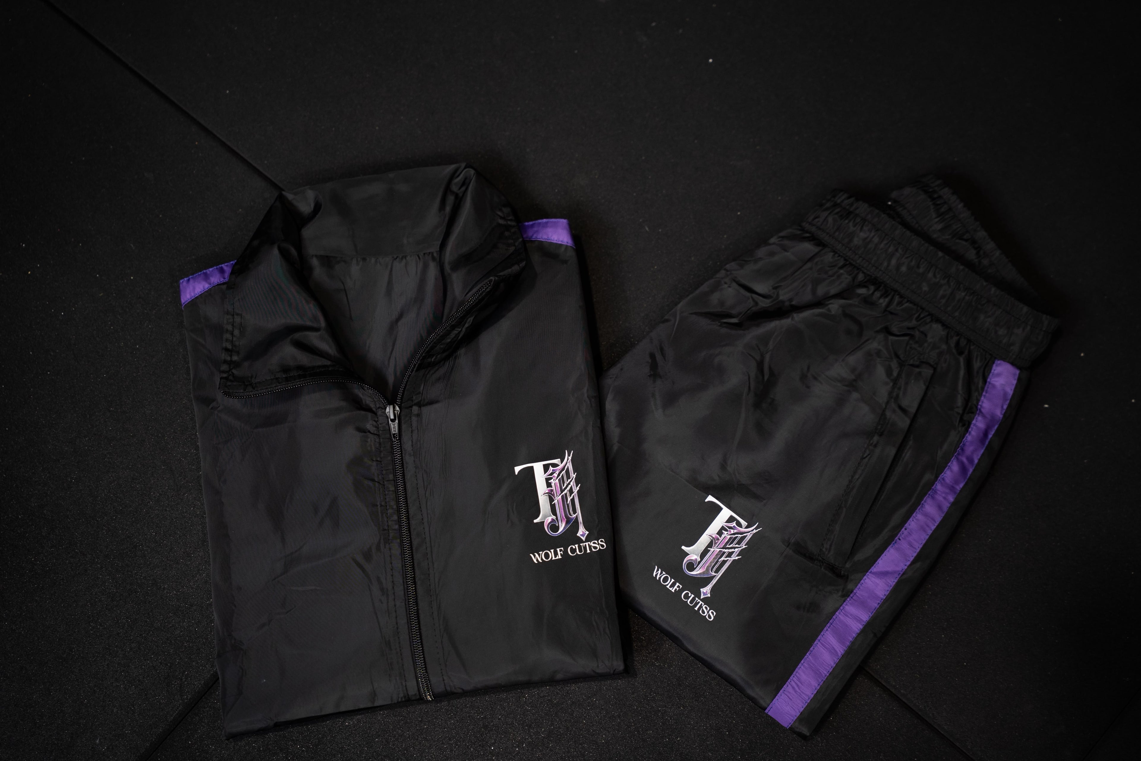 Full TJ Wolf Cutss black tracksuit set flat lay, jacket and pants together